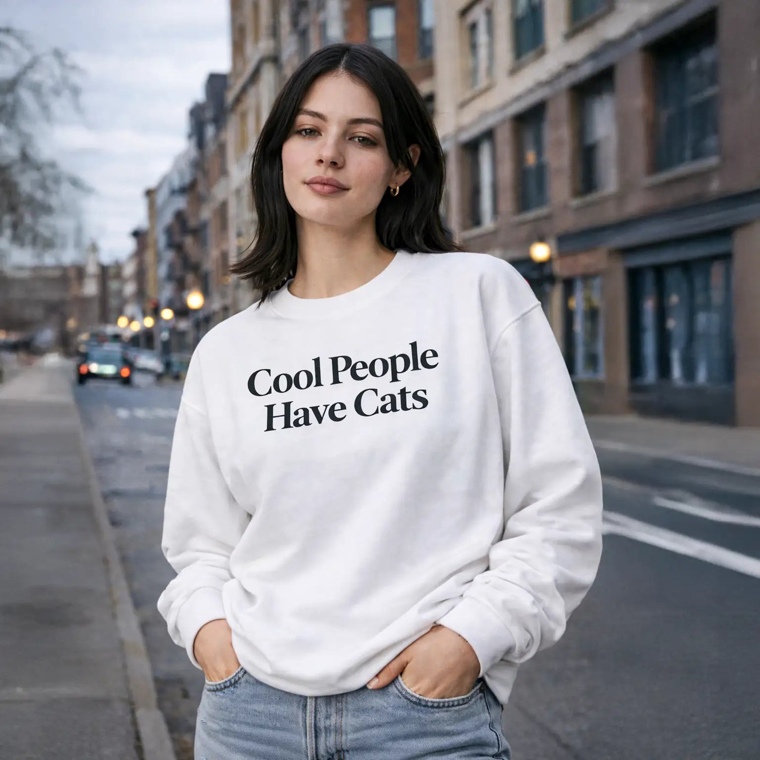Model trägt weißes Sweatshirt mit Aufdruck „Cool People Have Cats“ von Animor.