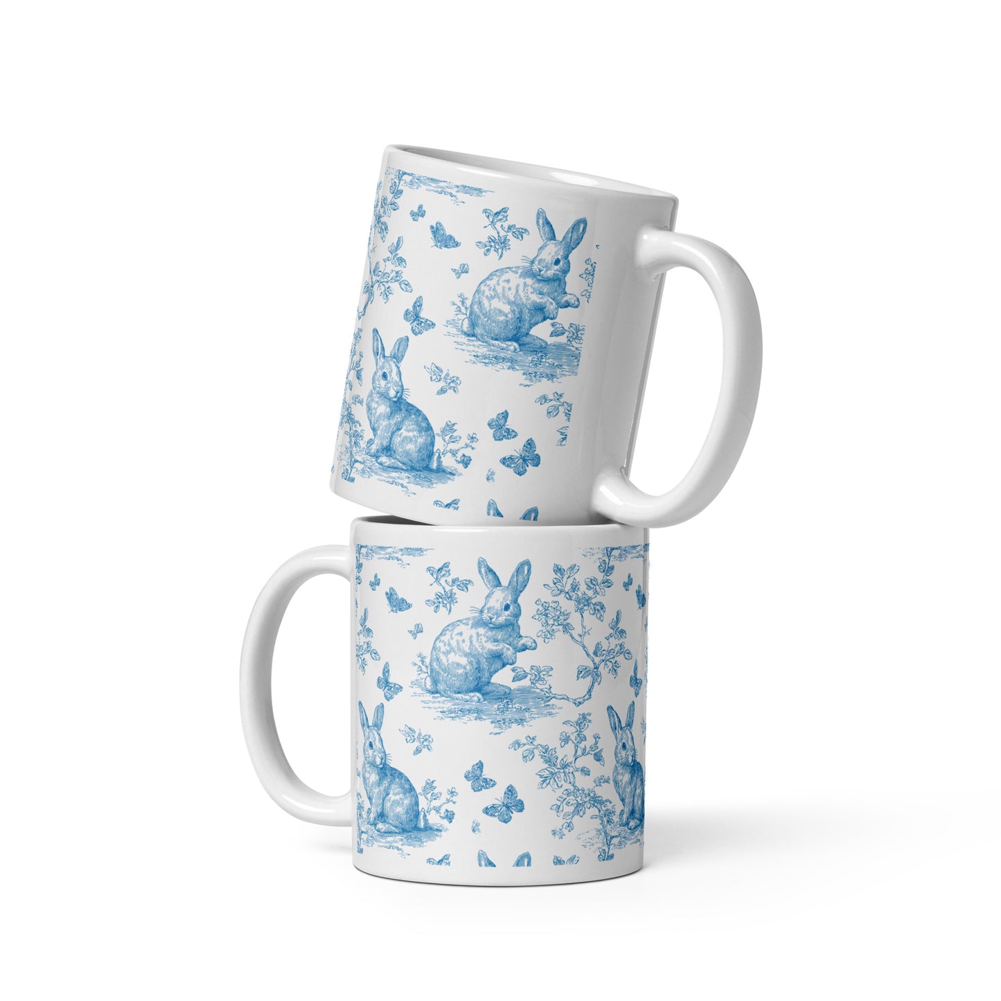 Weiße Keramiktasse mit blauem Hasen- und Blumenmuster im Toile De Jouy-Stil.