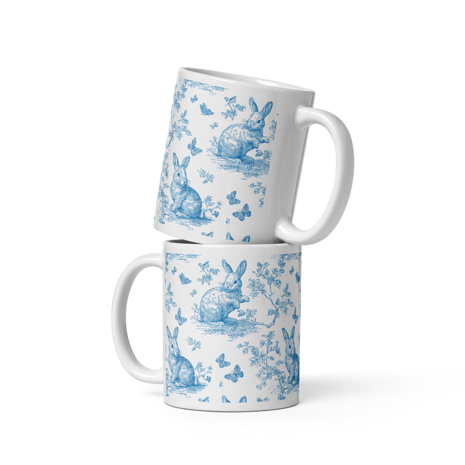 Weiße Keramiktasse mit blauem Hasen- und Blumenmuster im Toile De Jouy-Stil.