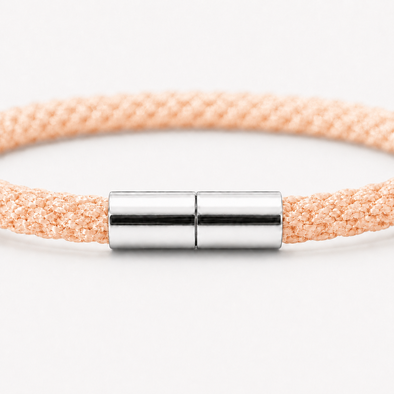 Detailansicht eines Kumihimo Armbands in Apricot Orange mit glänzendem Edelstahlverschluss.